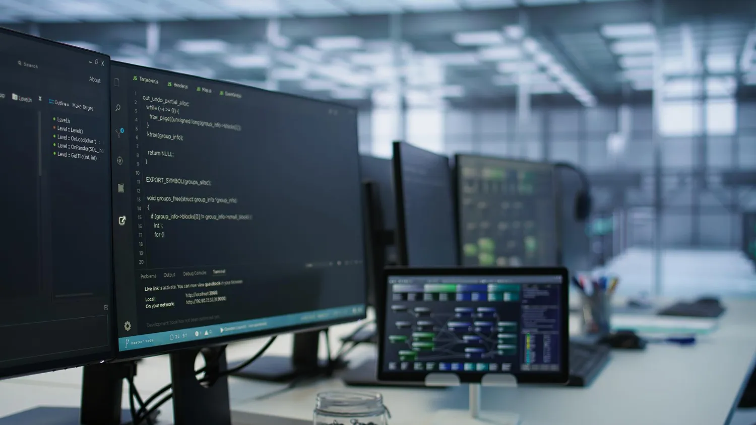 plusieurs ordinateurs sont posés sur un bureau et à disposition de professionnels de l'informatique